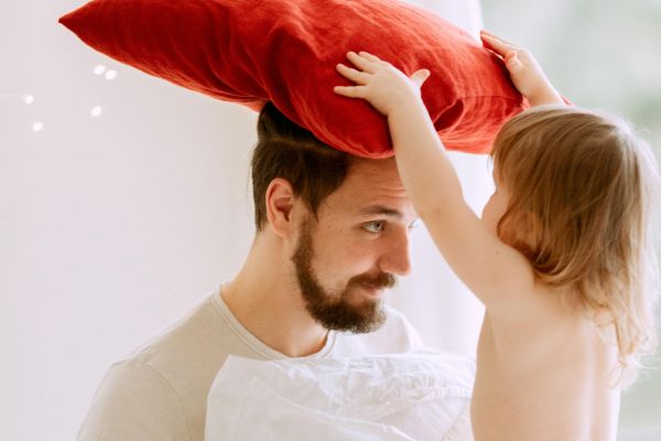 A Father and his Child Playing with Pillows
