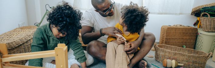 African American man playing with kids at home